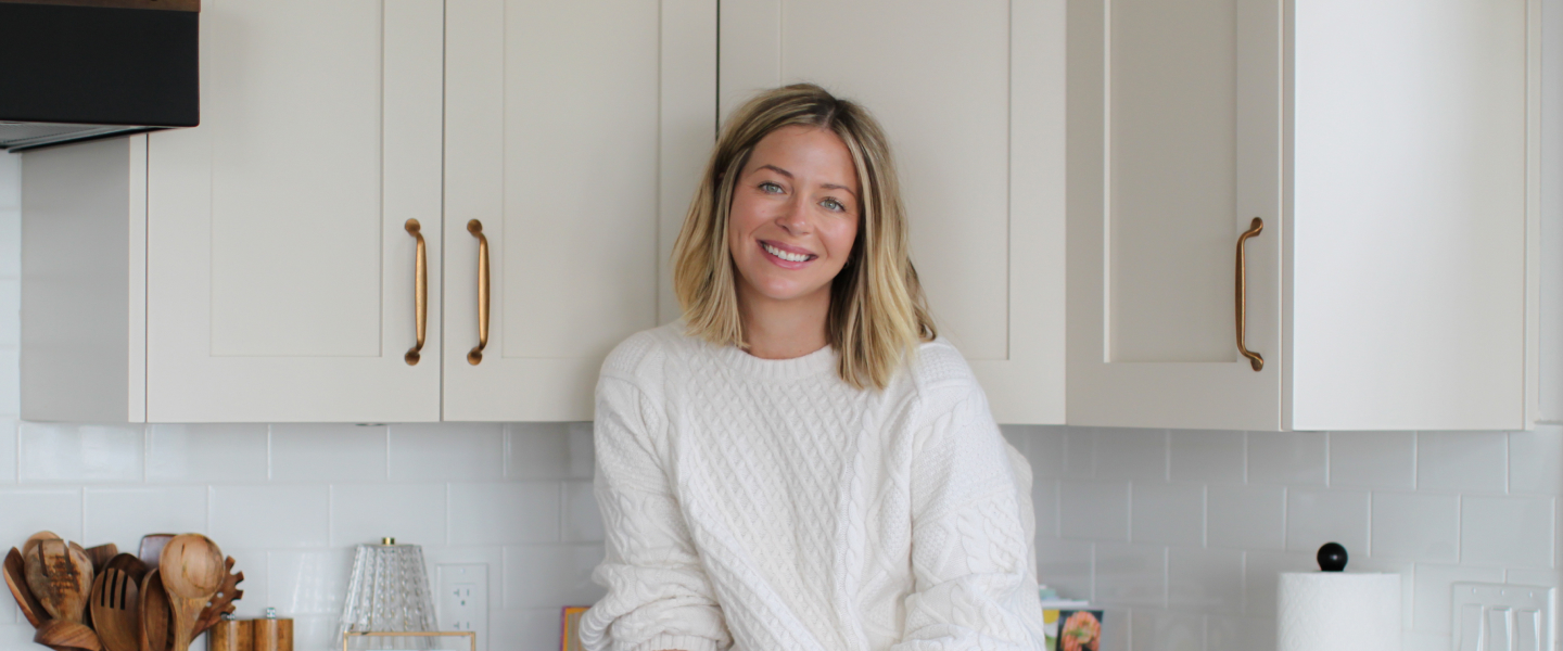 Sarah McAllister of the gocleanco team sitting on a counter smiling